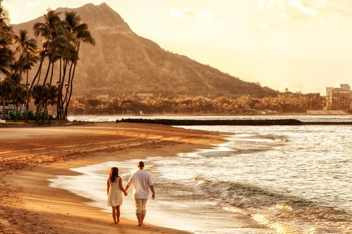 Happy Couple Walking on the Beach at Sunrise.