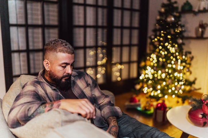 Man sitting on couch at Christmas.