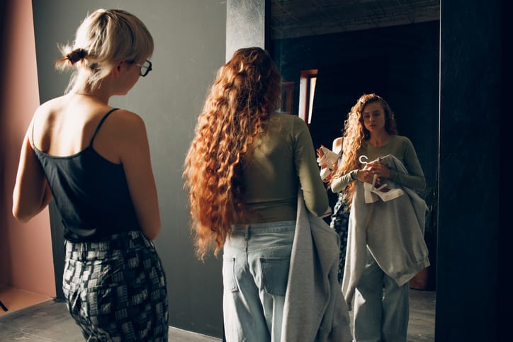 Woman helping one another get dressed.