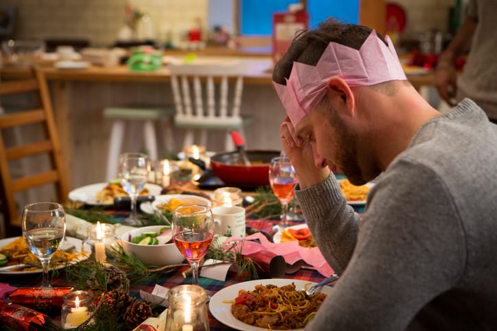 Man sitting at Christmas dinner table alone.