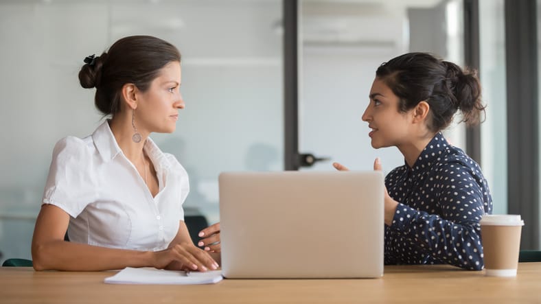 Enthusiastic young employee sharing new project ideas with female boss.