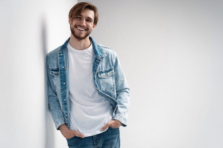 Fashion portrait of young man wearing jeans jacket.