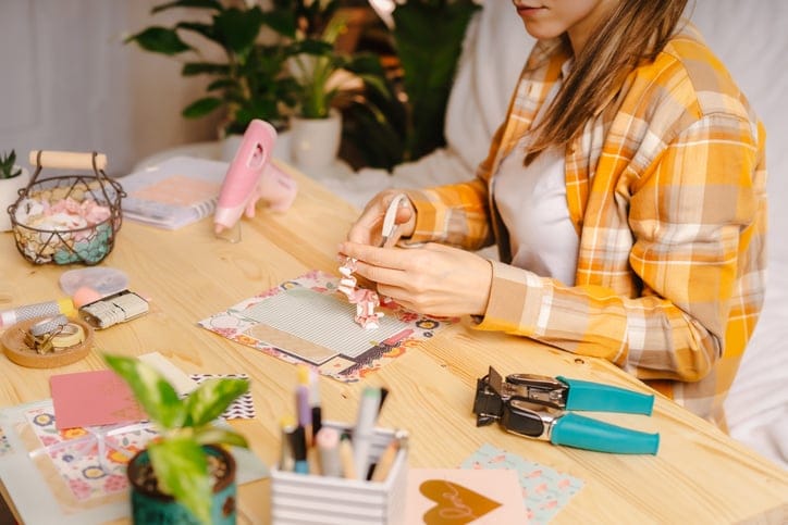 Cropped shot of women making homemade scrapbooking album from paper.
