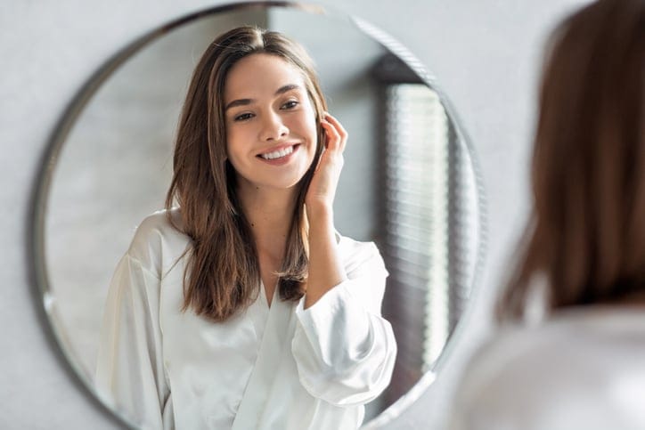 Attractive woman looking in the mirror.