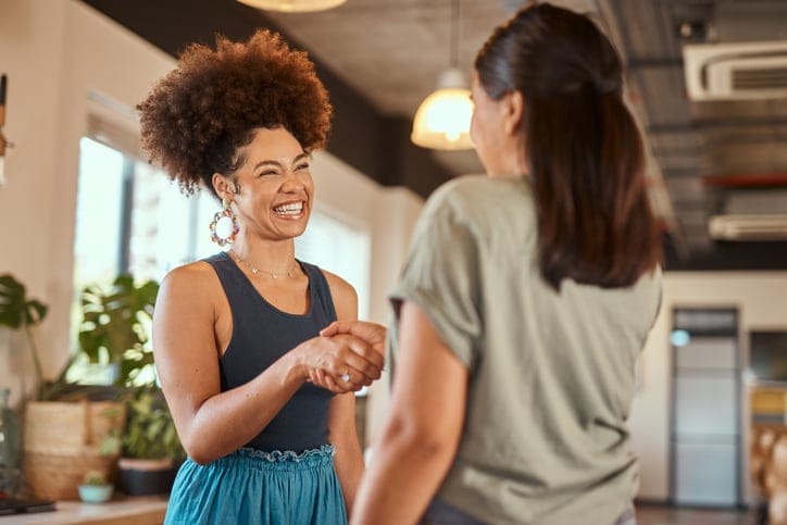 Businesswoman shaking hands with a female colleague.