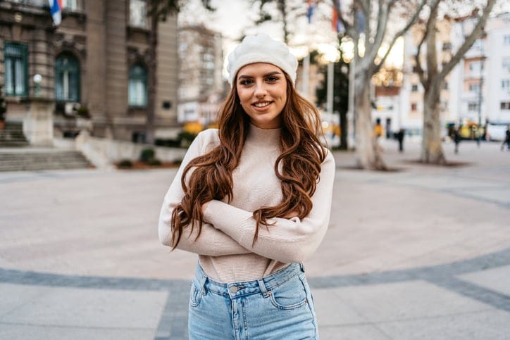 smiling woman arms crossed outside in winter