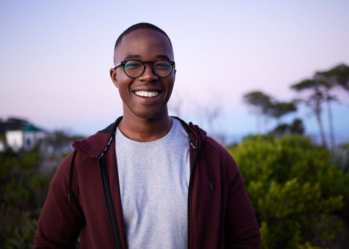 Man smiling on a walk outside.