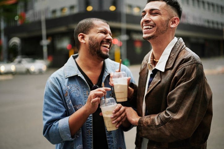 Two men laughing on city street.