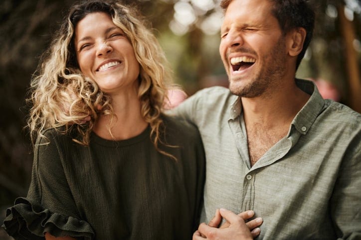 Carefree couple having fun while laughing and taking a walk in spring day.
