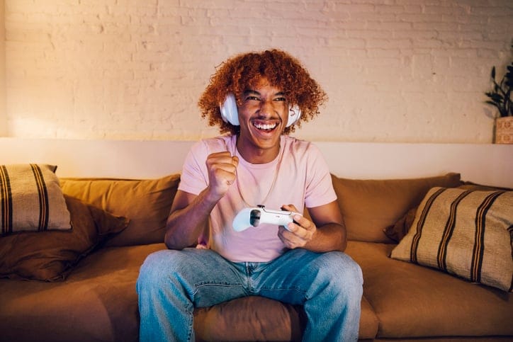 Young man with headphones playing video games.