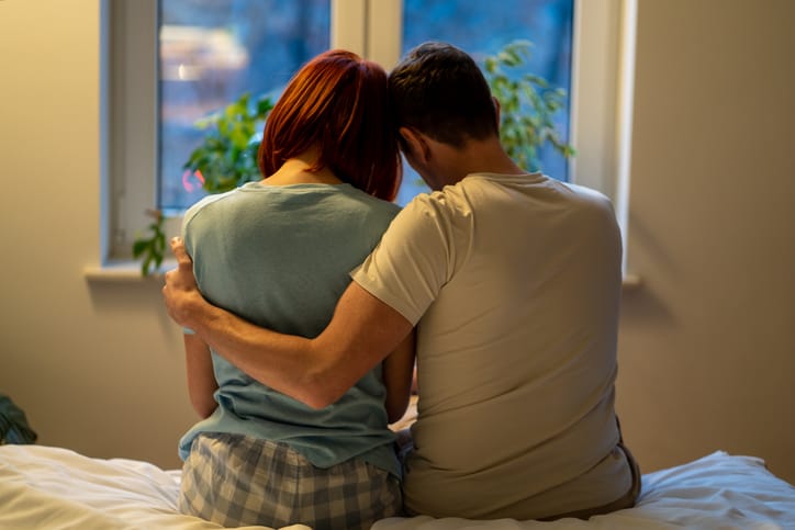 Loving man calms down upset wife after quarrel.