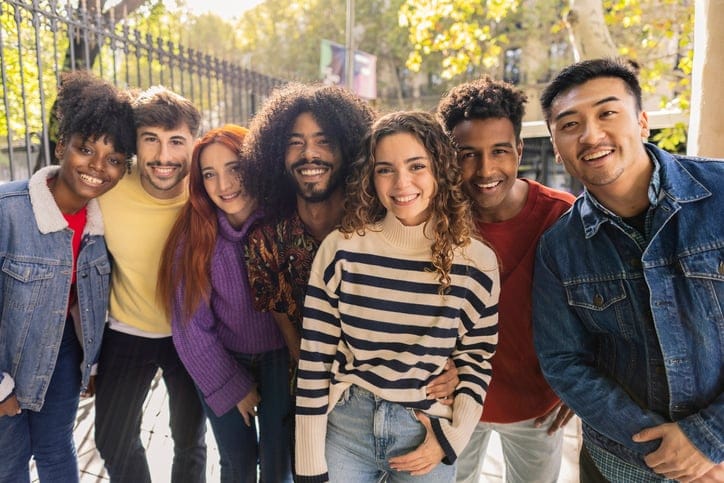 Group of smiling friends on city street.