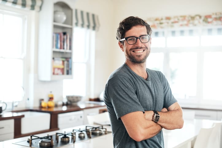 Man in the kitchen smiling.