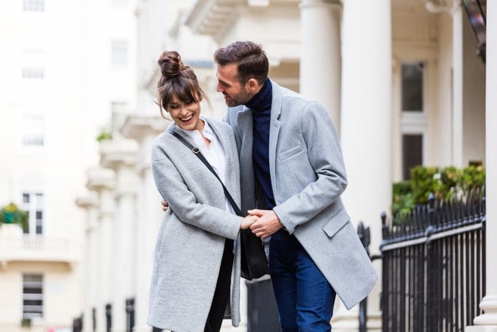 Couple walking outdoors hand in hand.