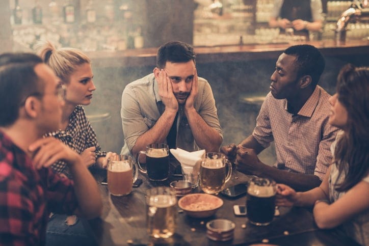 Upset guy out with group of friends.