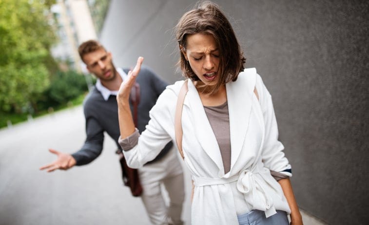 Man and sad girlfriend outdoors.