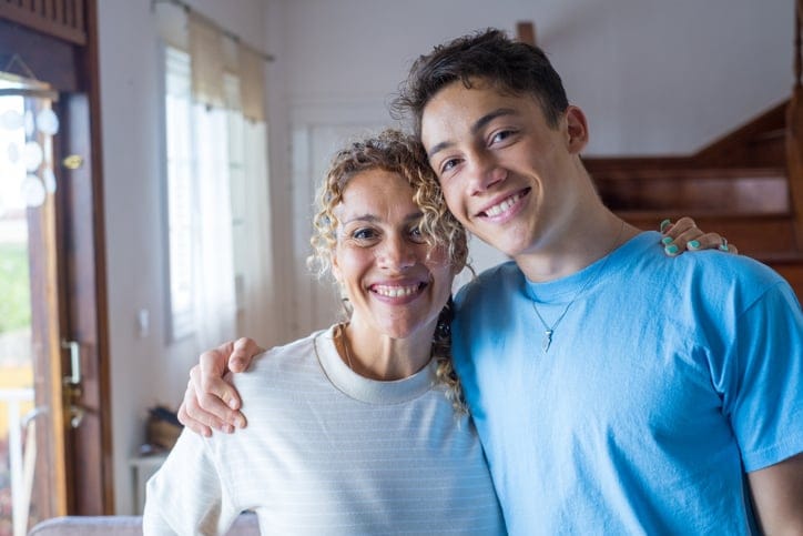 Teenager hugging middle-aged mother.