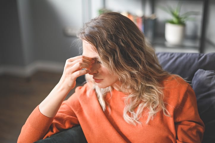 Woman with her head down looking annoyed.
