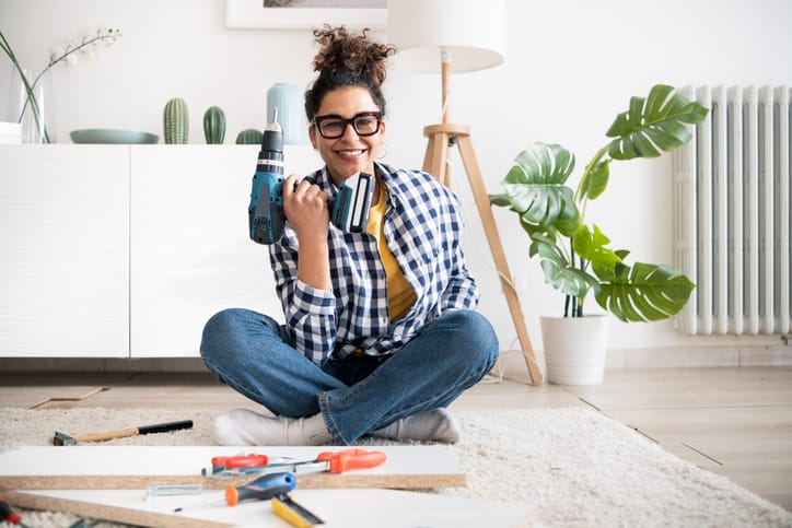 Woman sitting with tools on floor.