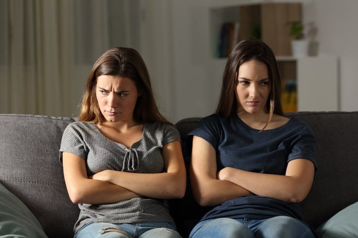 Angry friends ignoring each other.