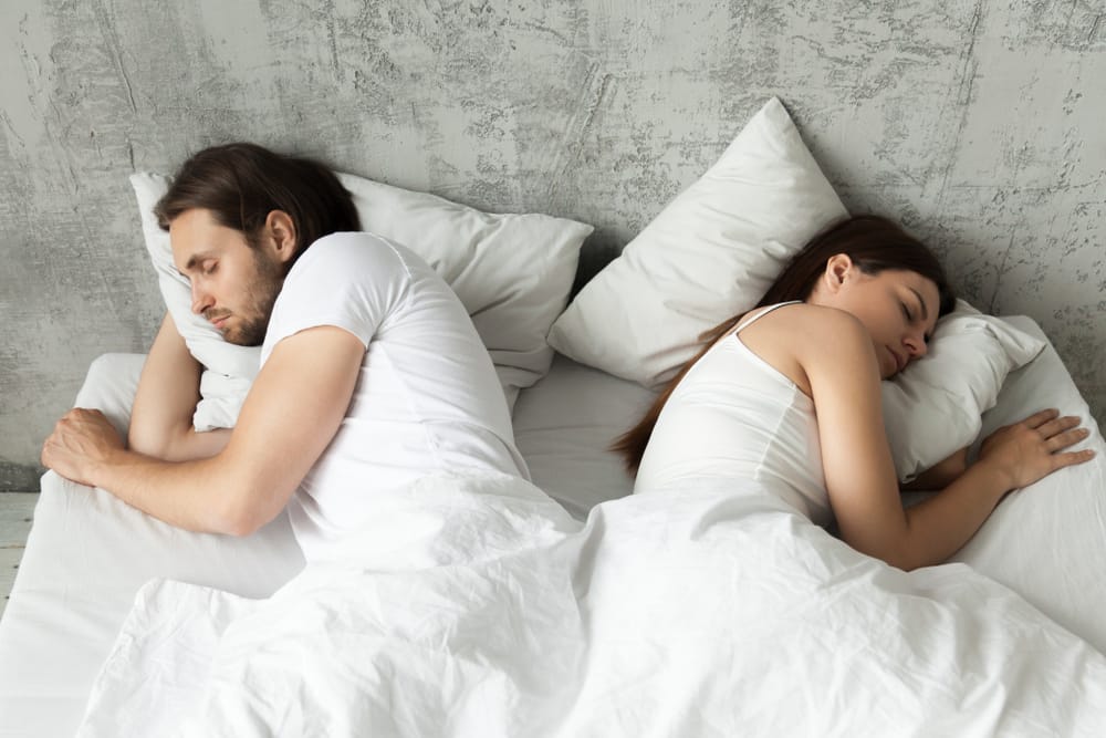 Unhappy couple laying in bed.