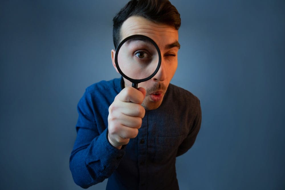 Man with a magnifying glass at his eye.