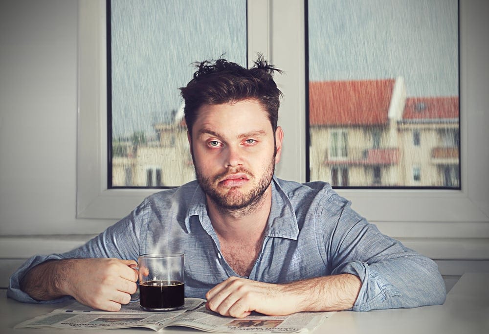 Guy pulling a face and looking sleepy first thing in the morning.