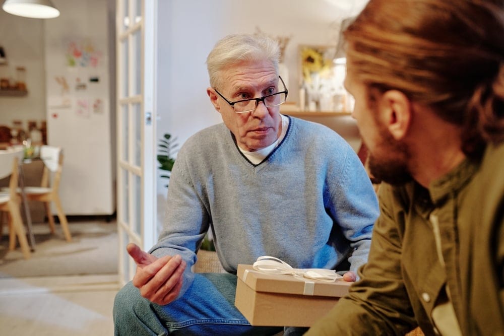Mature man holding a gift box.