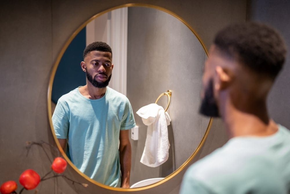 Man looking at himself in the mirror.