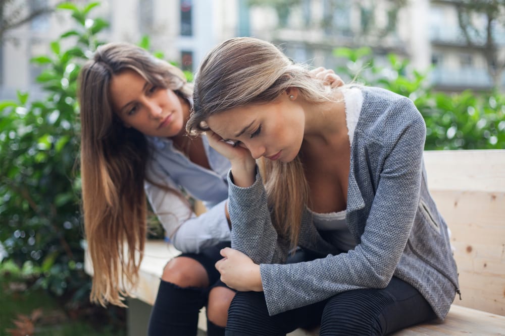 Woman comforting her friend.