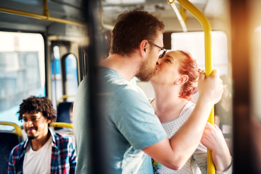 Couple kissing on the bus.