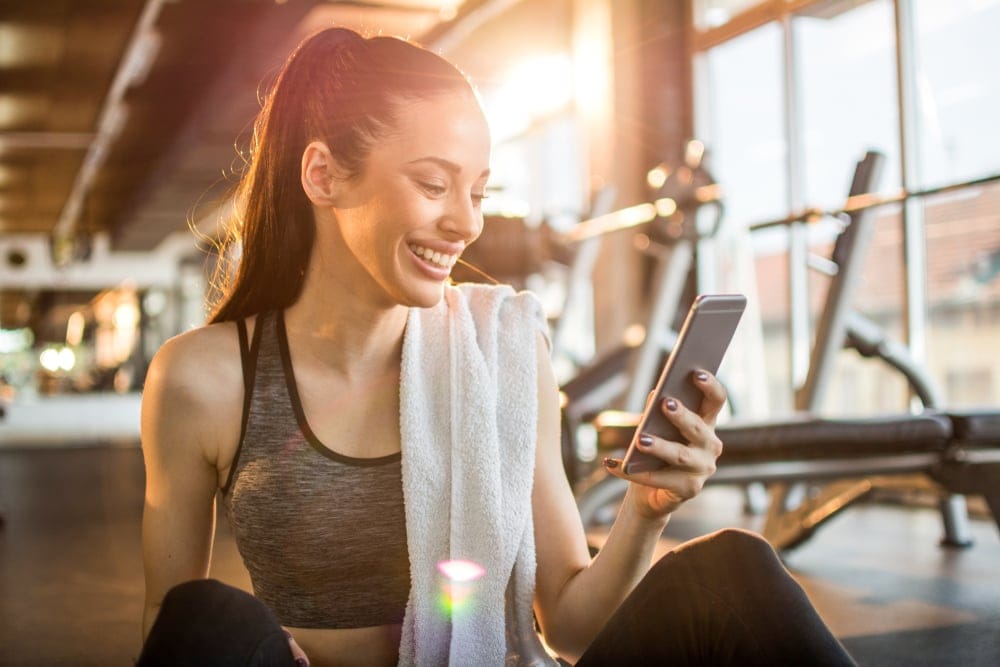 Woman at the gym on her phone.