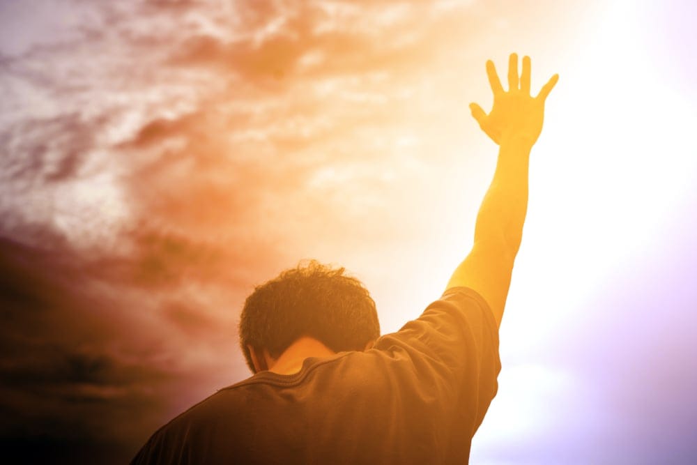 Man with his arms stretched to the sky.