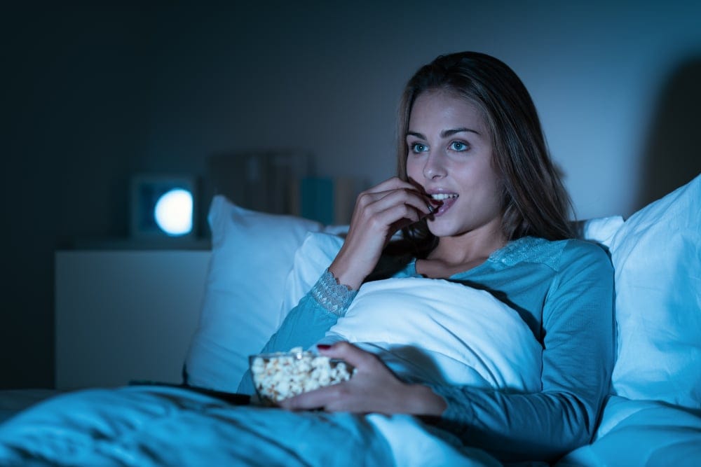Woman in bed watching TV.