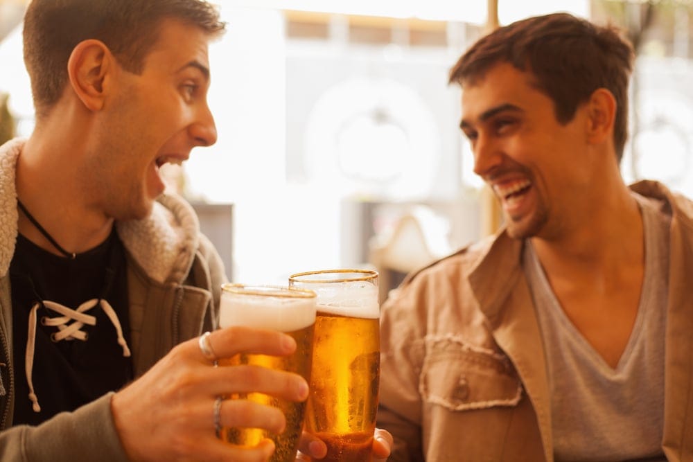 Young men at a bar having a drink.