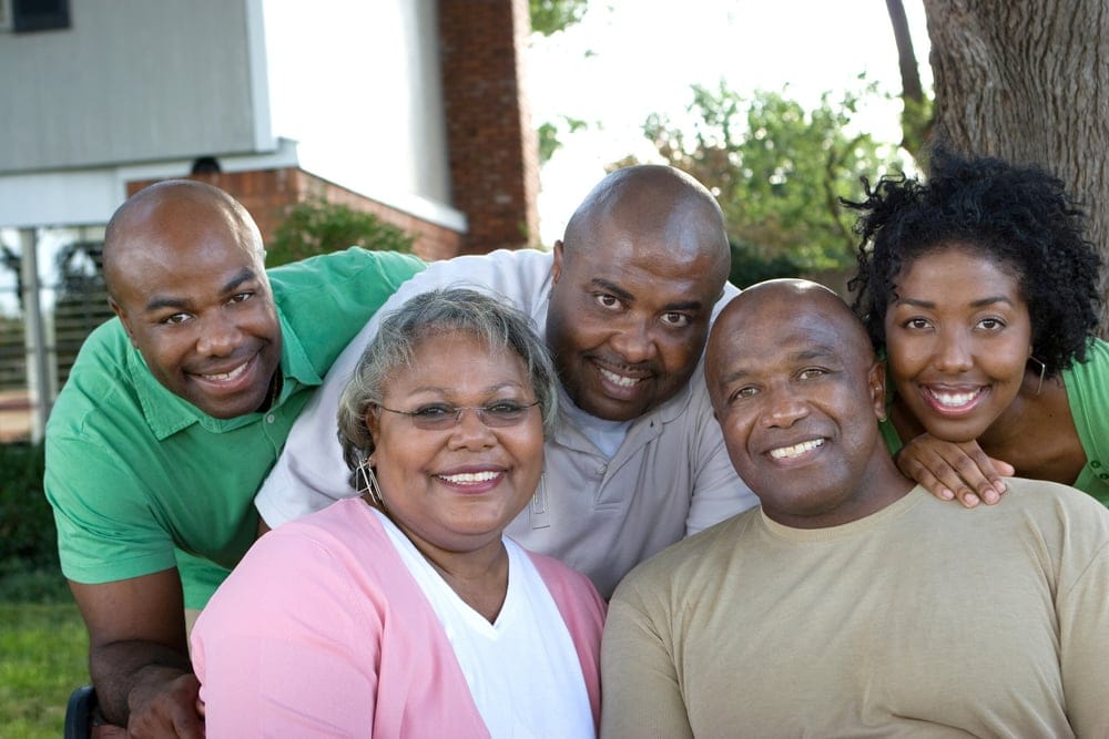 A happy family posing outside.