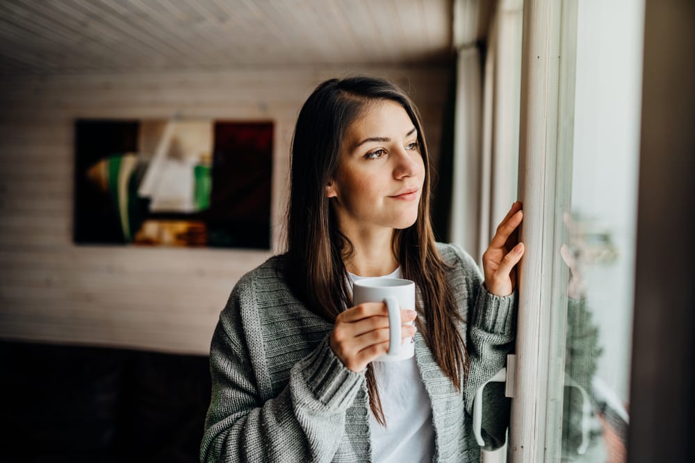 Woman looking out the window and thinking.