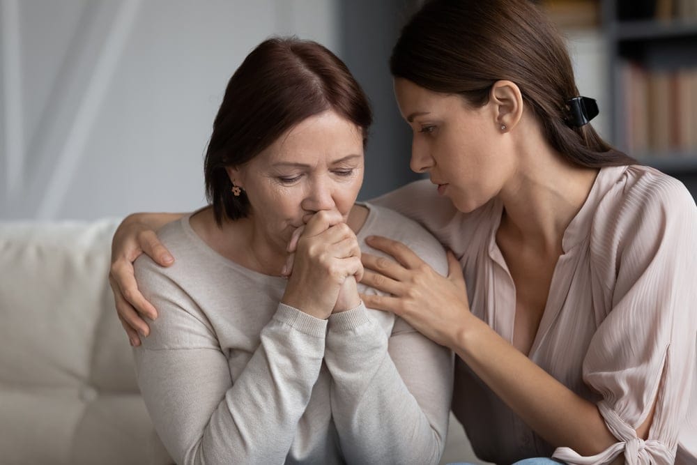 Mother and daughter embracing at home.