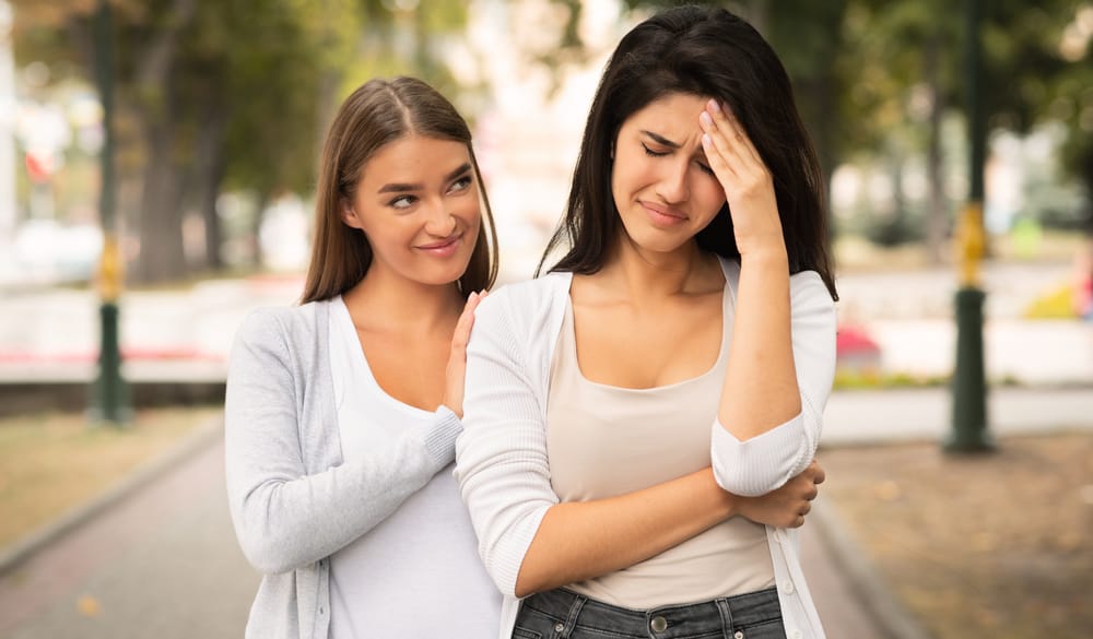 One friend being fake to the other and taking pleasure in her pain