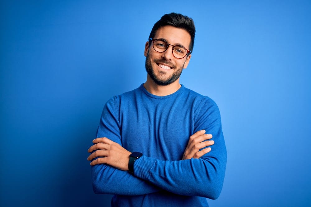 Man smiling in a blue sweater.