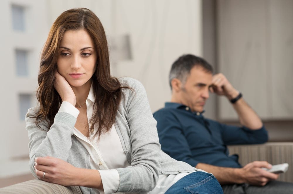 Unhappy couple sitting on the couch.