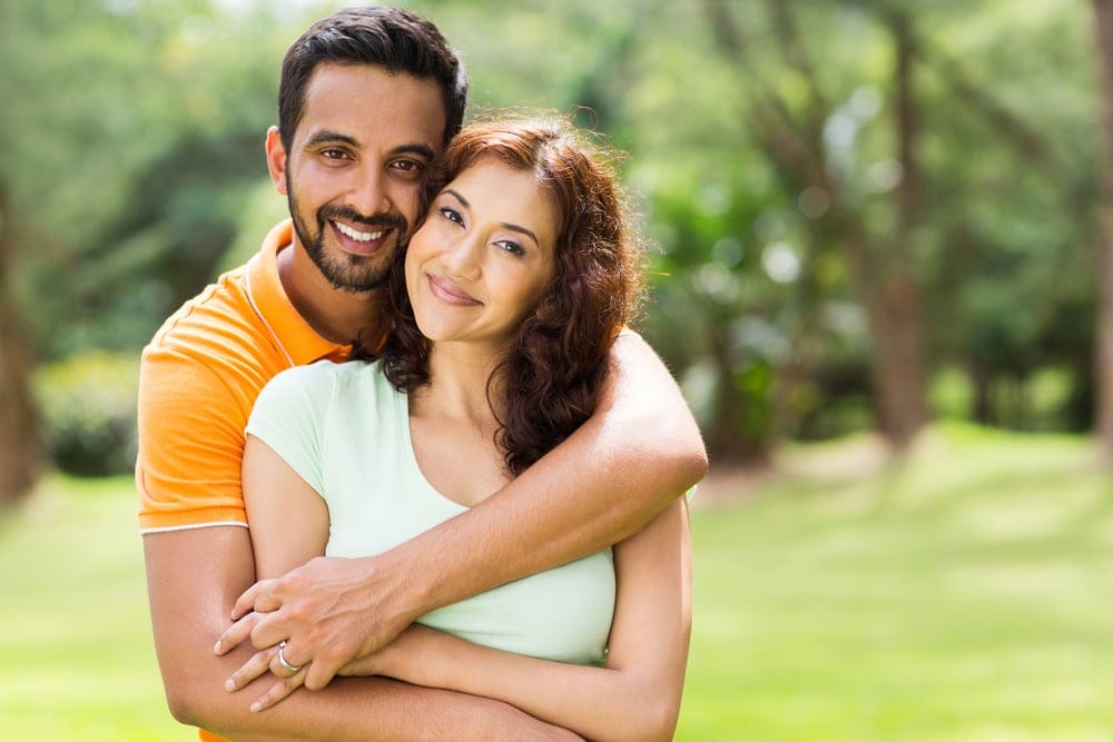 Young couple embracing outside.