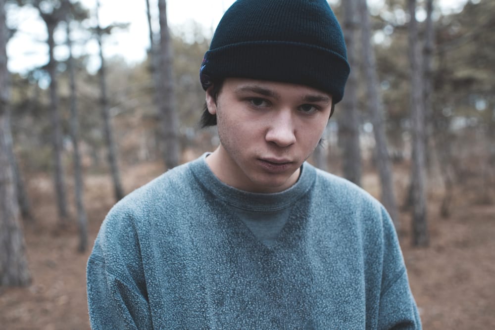 A sad teenage boy walking alone.