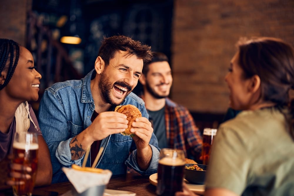 Happy man enjoying a hamburger.