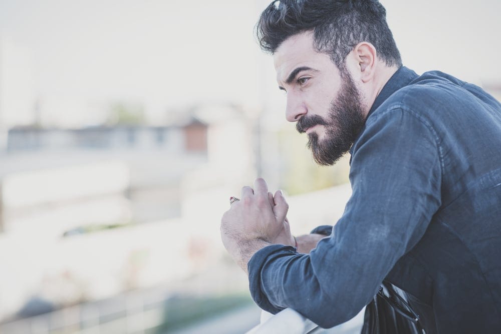 Man looking out the window deep in thought.