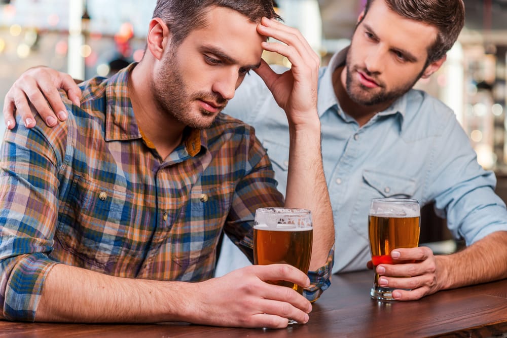 A man consoling his depressed male friend