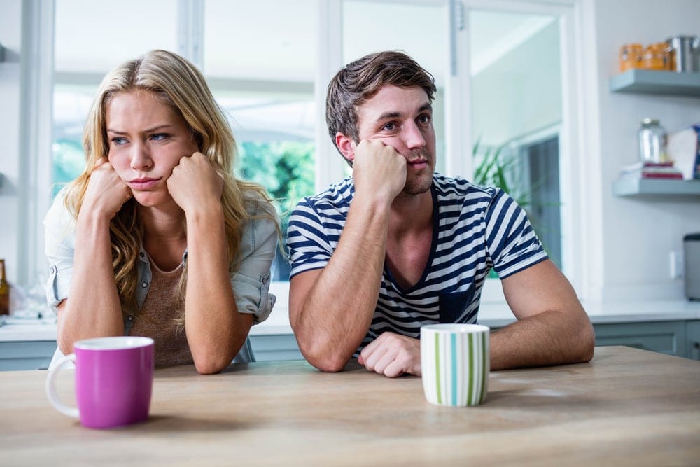 Annoyed couple sitting at home.
