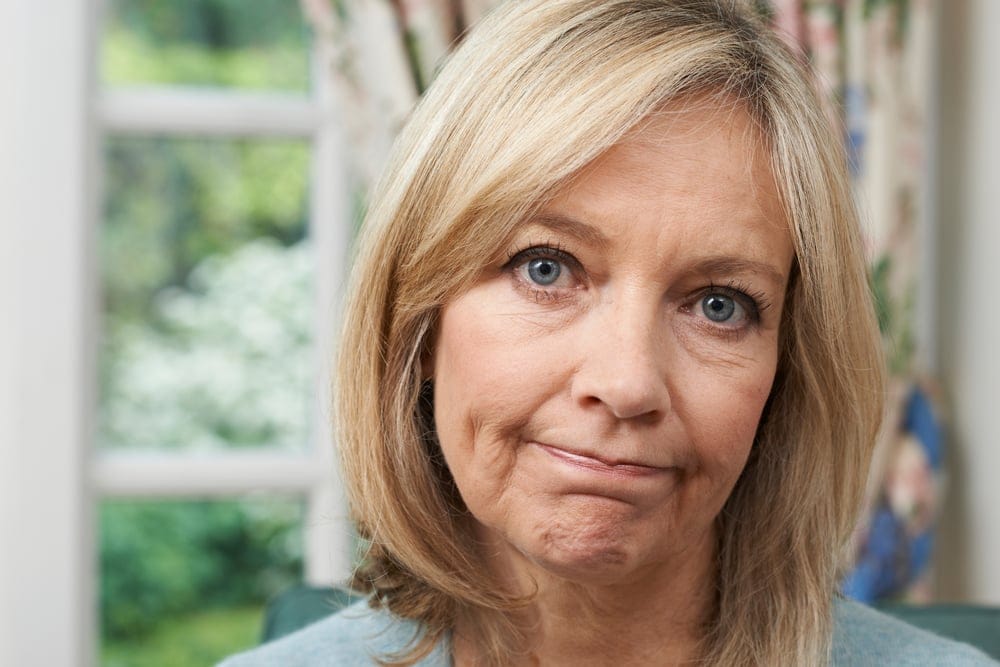 A sad blonde middle age woman
