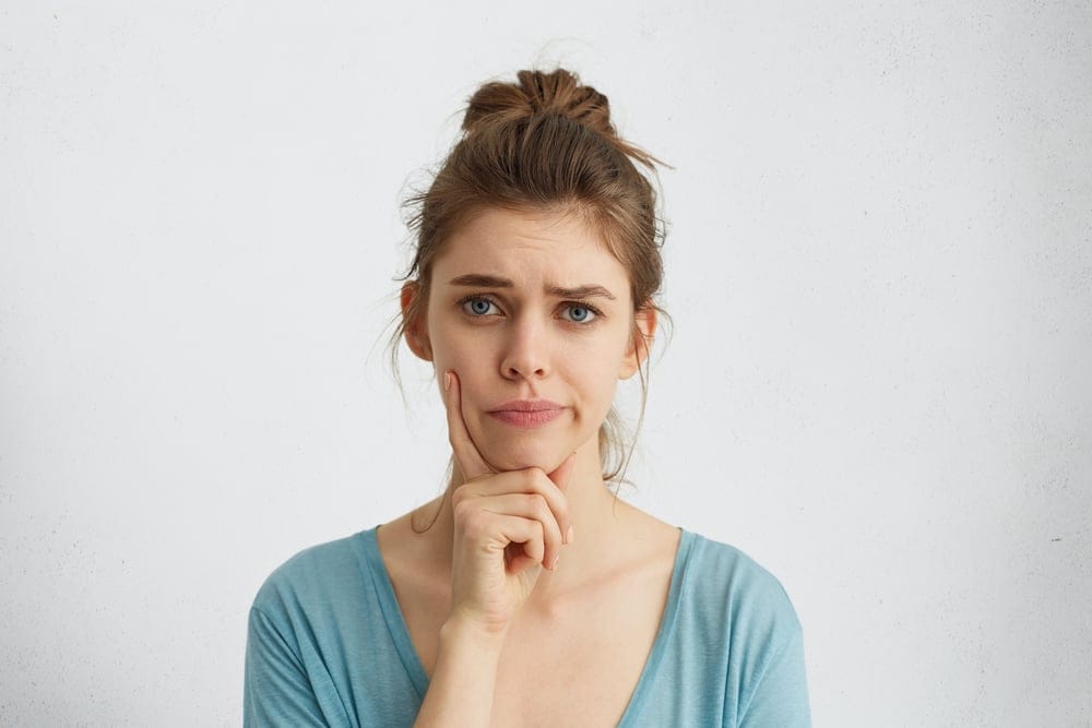 Young woman with her hand on her chin.