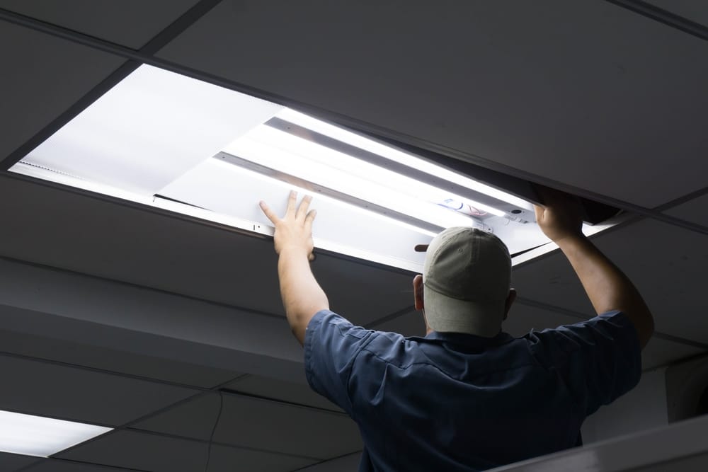 Man replacing a fluorescent bulb.